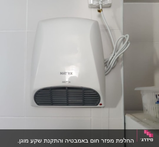 מייבש ידיים חשמלי מותקן על קיר עם חוט חשמל